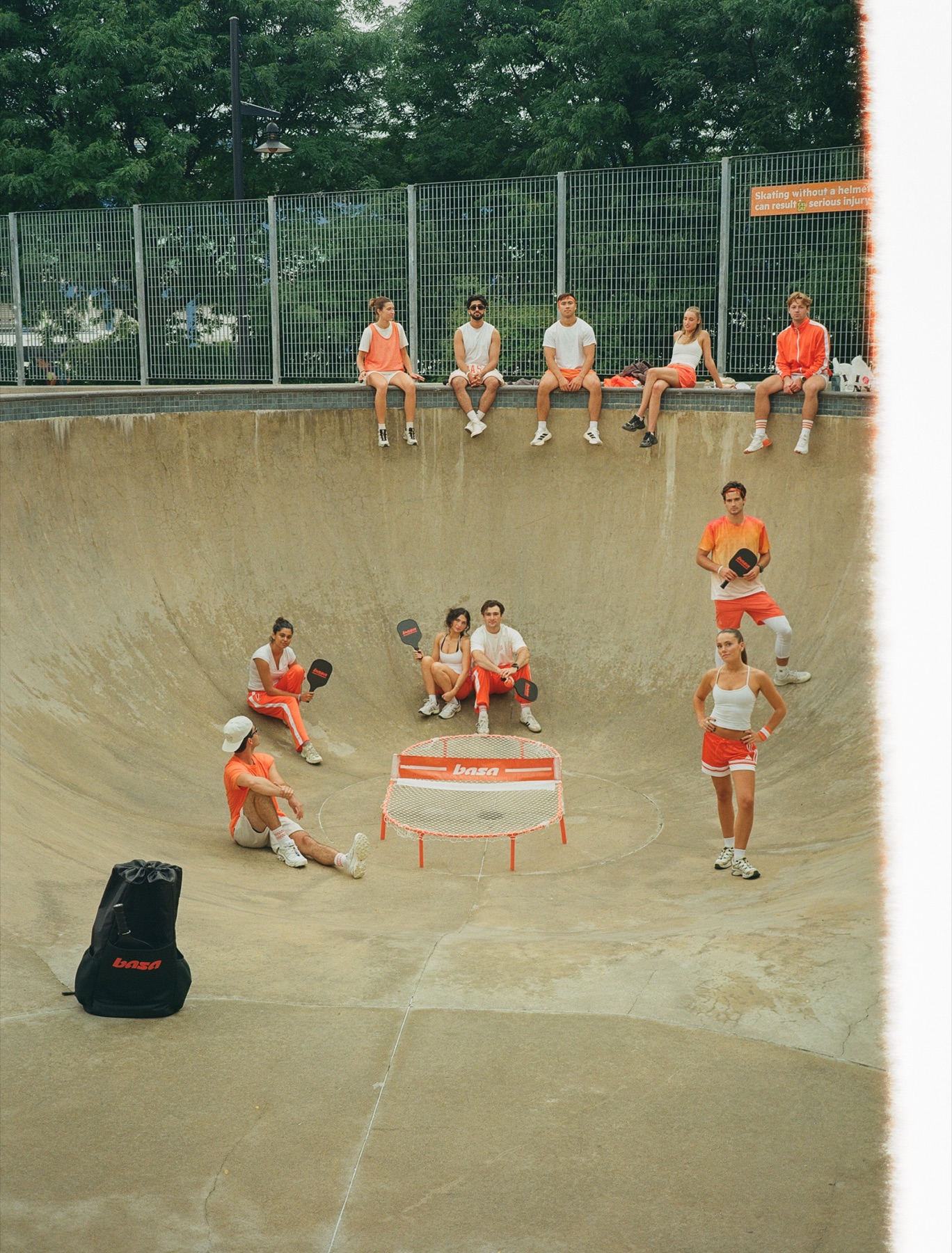 Players around the basa net in a skatepark bowl